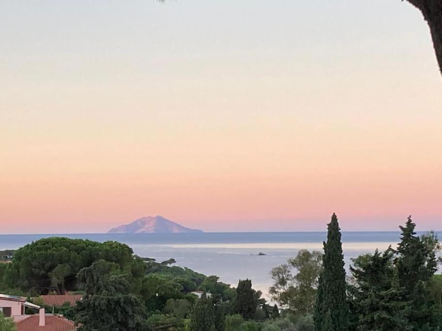 a view of a mountain in the ocean at sunset at Villa Barabarca in Capoliveri