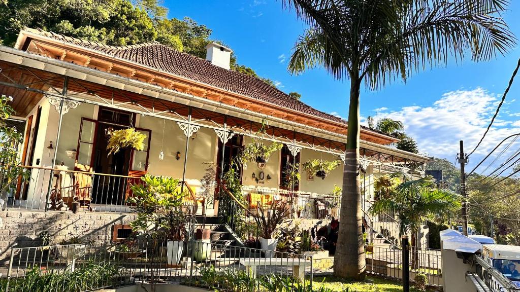 a house with a palm tree in front of it at Casa Verde Petrópolis in Petrópolis