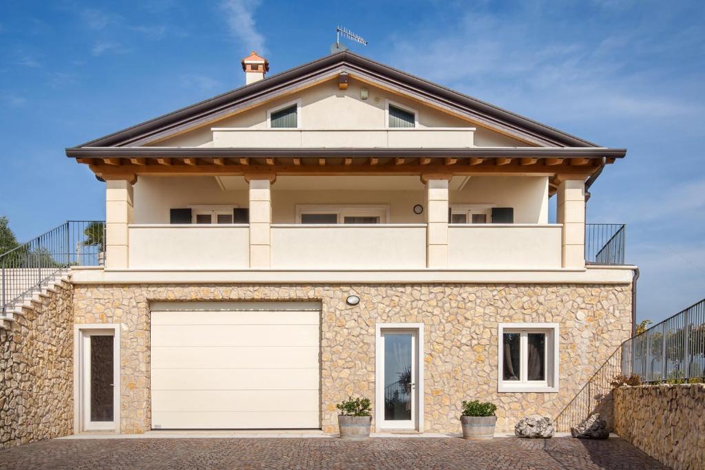 een wit huis met een witte garagedeur bij Villa Oleandri in San Pietro in Cariano