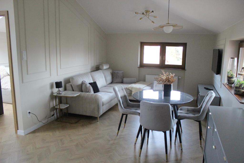 sala de estar con sofá y mesa en Apartament na Helskiej en Rewa