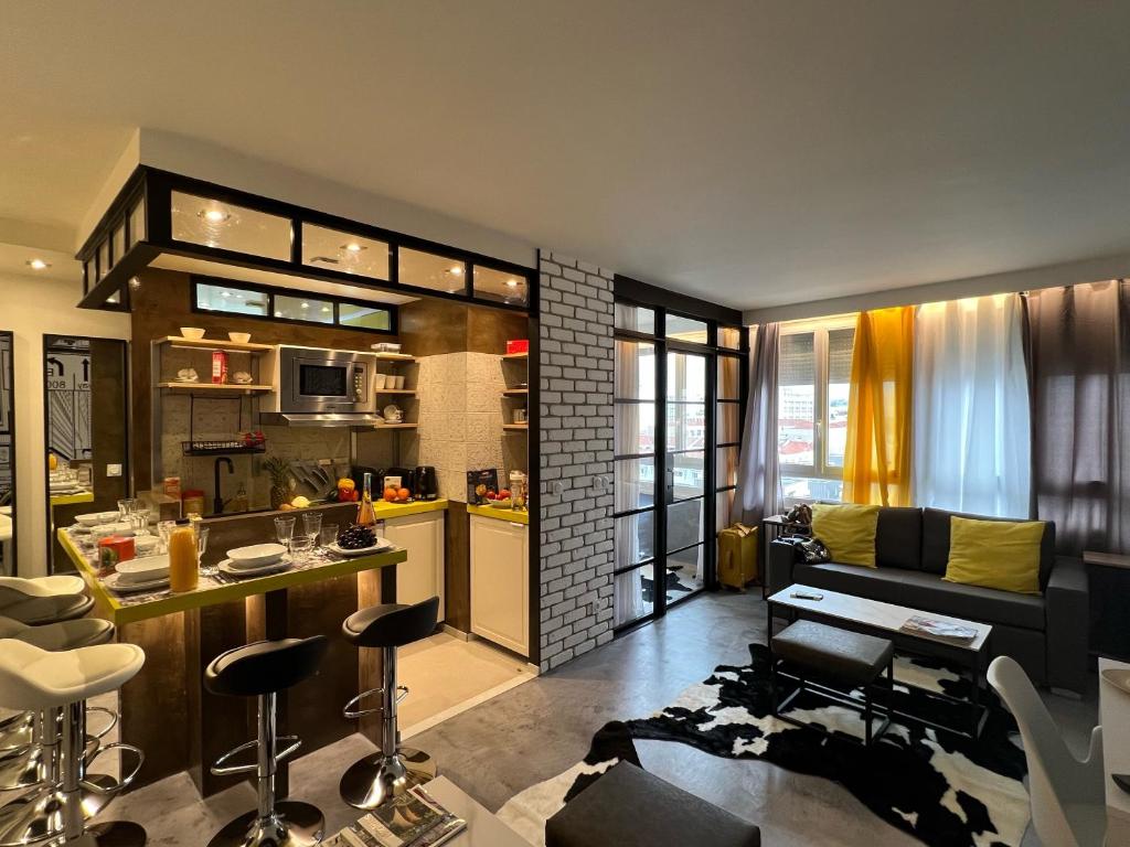 een woonkamer met een bank en een keuken bij Appartement Flandre in Parijs