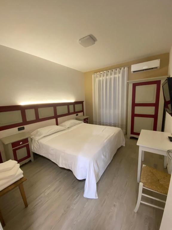 Un dormitorio con una gran cama blanca y una mesa en Romantica camere Le Fate con Vista sulle Montagne vicino a Bassano del Grappa, en Romano D'Ezzelino