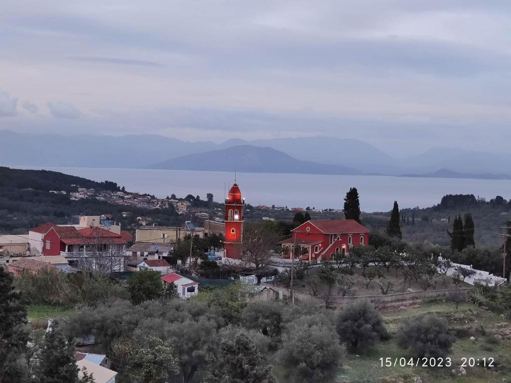 a town with a red clock tower in the distance at CORFU FOTIS house in Neochorákion