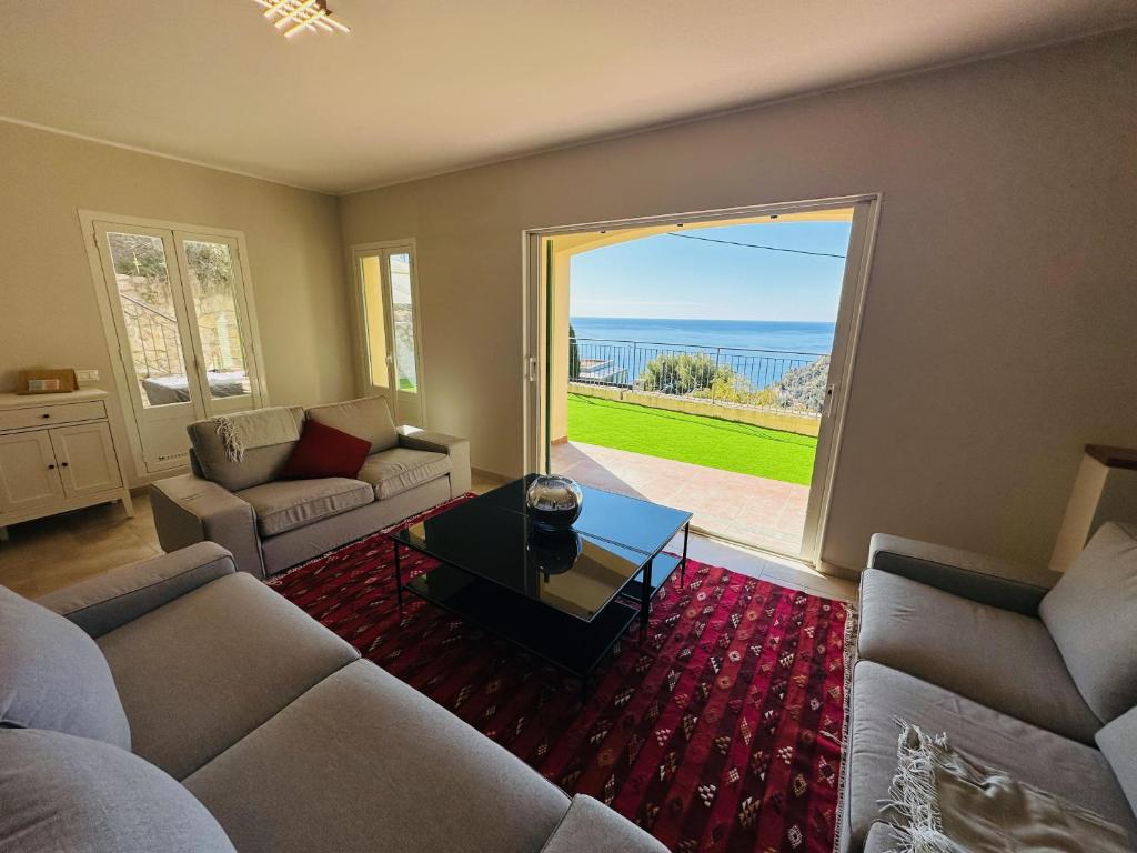 - un salon avec un canapé et une vue sur l'océan dans l'établissement Maison Vue Mer Eze sur Mer, à Èze