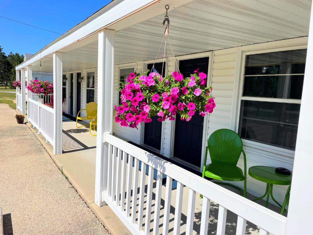 a porch with pink flowers in a hanging basket at Hillcrest Inn & Motel in Rapid River