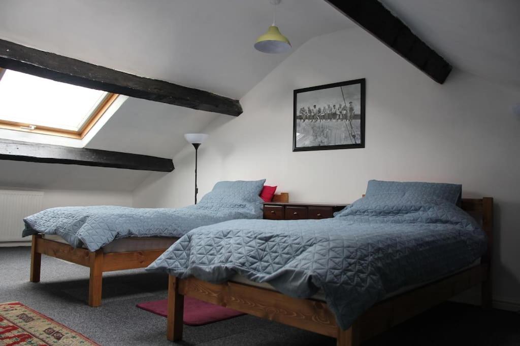 1 dormitorio con 2 camas y ventana en Kingfisher Cottage, en High Bentham