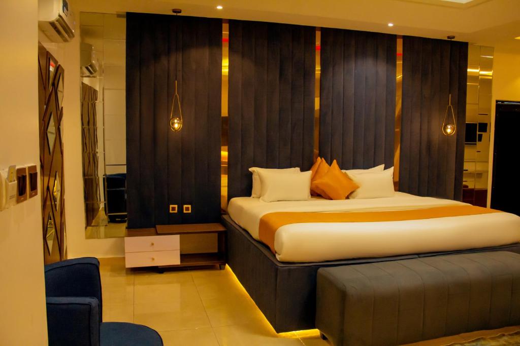a bedroom with a large bed and a mirror at Moratel Hotels in Port Harcourt