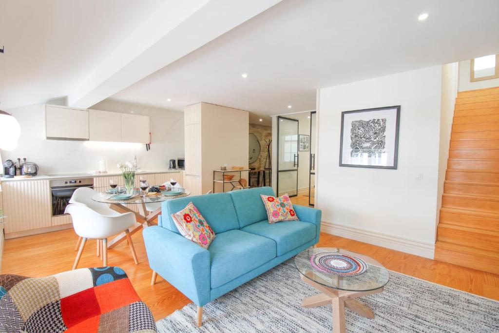 a living room with a blue couch and a table at Porto Unique Cosy Duplex in Porto