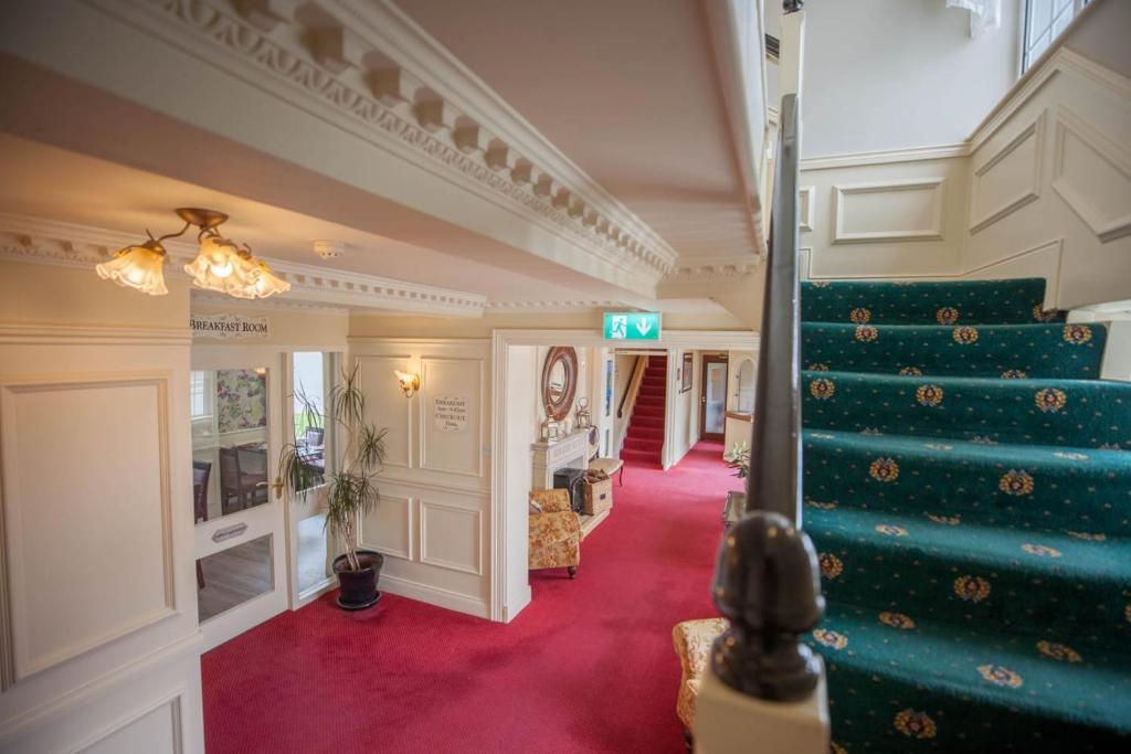 una scala in una casa con un tappeto verde di Castle Lodge a Killarney