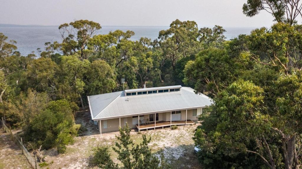 una casa en una colina con el océano en el fondo en Acacia Lakehouse en Goon Nure