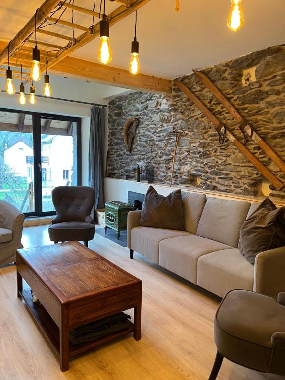 een woonkamer met een bank en een tafel bij Spacious town house in the center of le Bourg d'Oisans in Le Bourg-dʼOisans