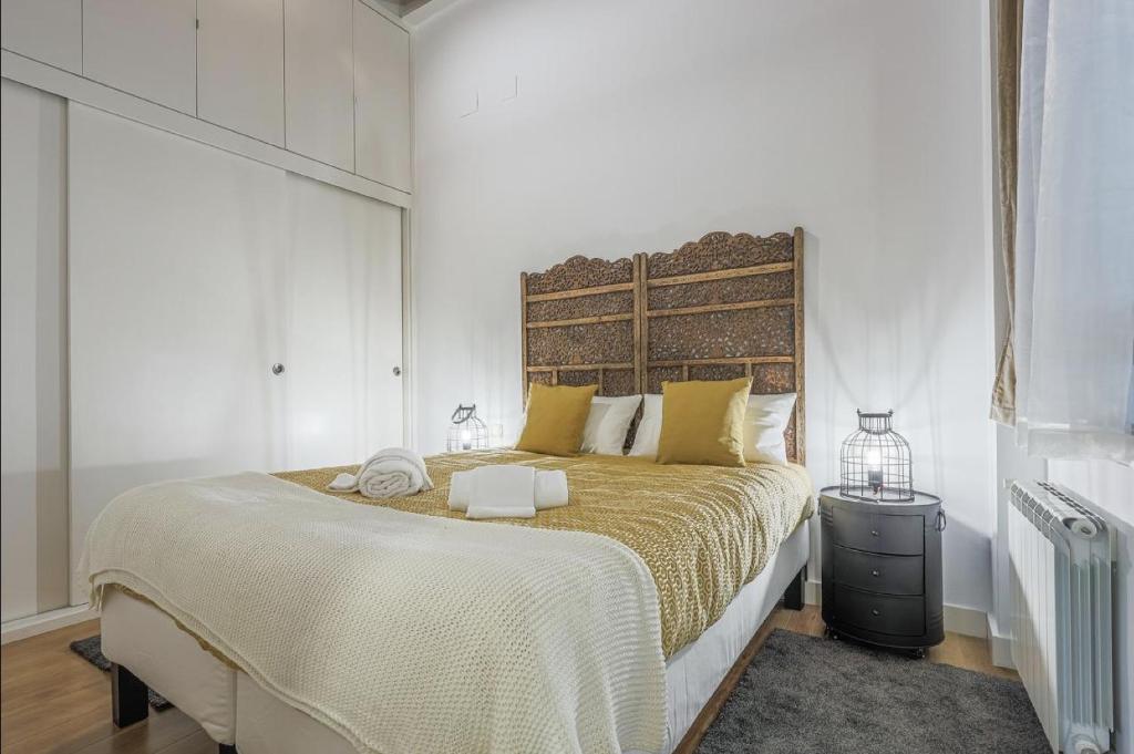 セビリアにあるAlohaMundi Castellarの白いベッドルーム(大型ベッド1台、黄色い枕付)