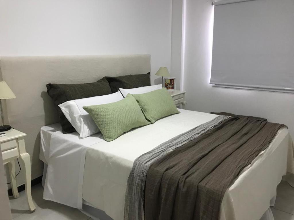 Un dormitorio con una gran cama blanca con almohadas verdes. en CALMA, en La Rioja