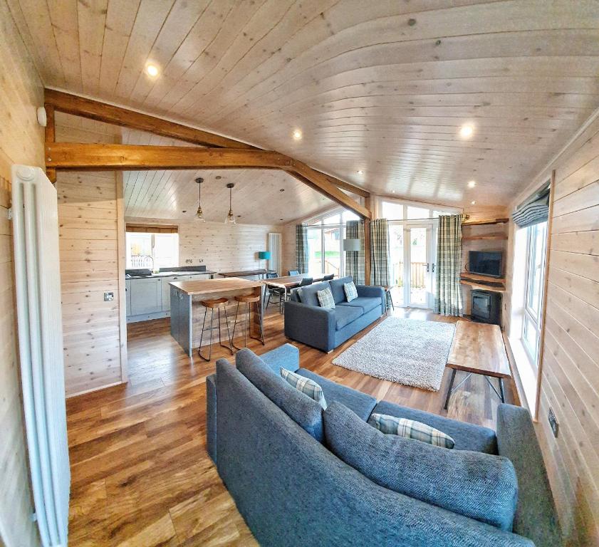 a living room with two blue couches and a kitchen at MAC Skyline Lodges in Balloch