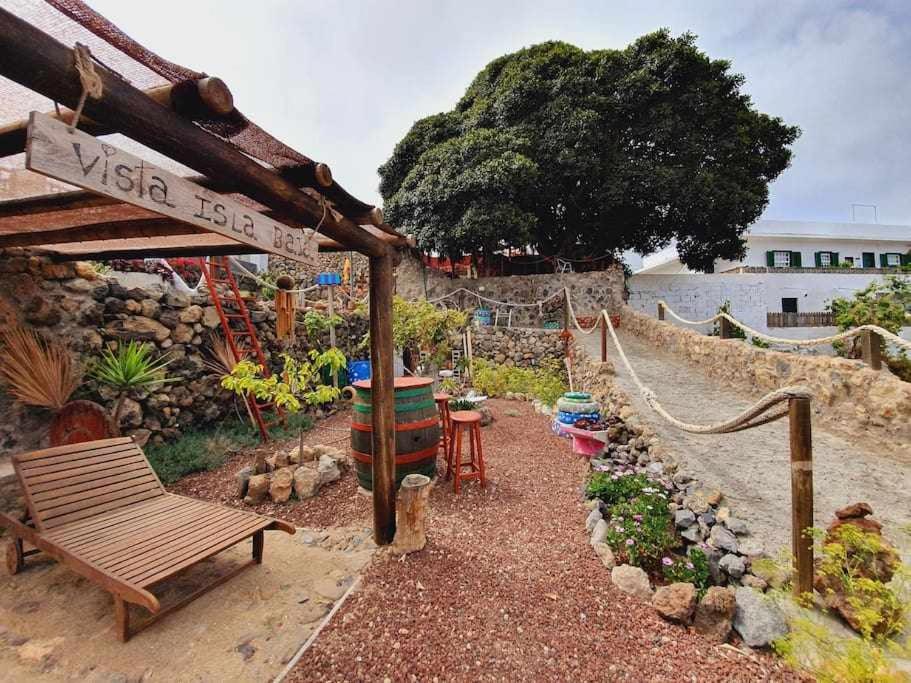 a garden with a bench and a hammock and a tree at La Bodeguita Apartamento Santo Domingo in La Guancha