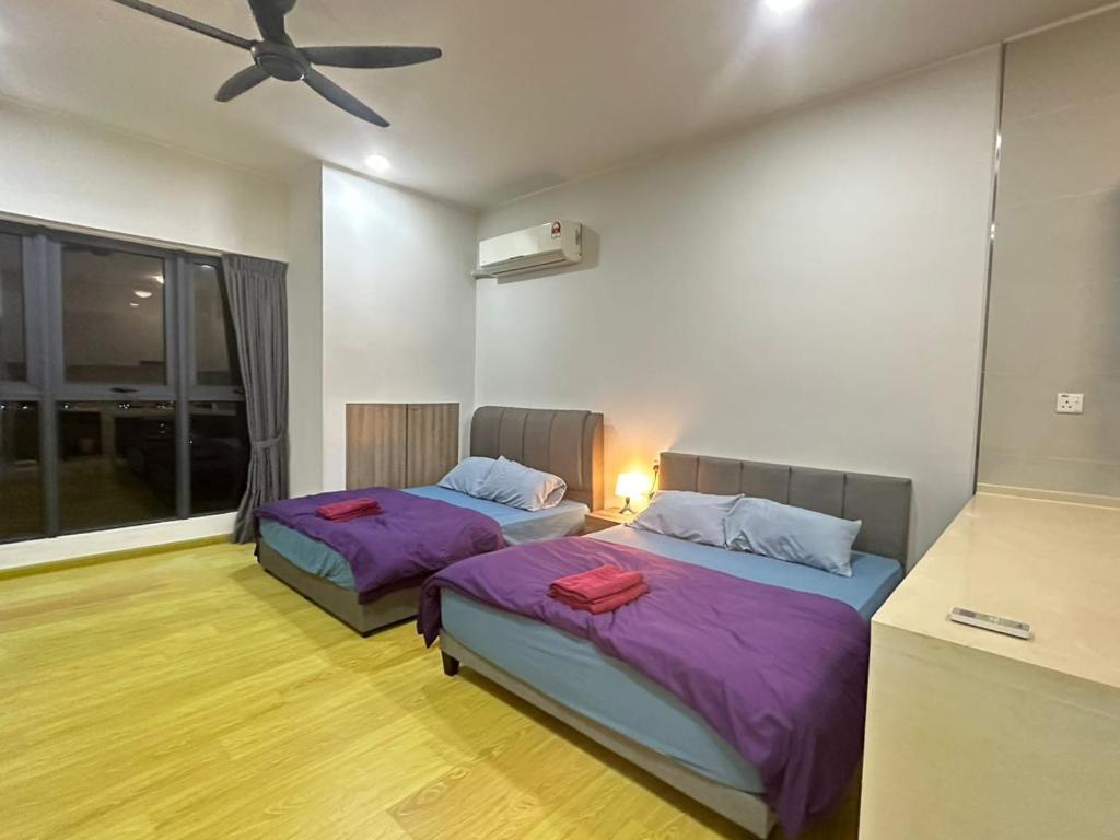 een slaapkamer met twee bedden en een plafondventilator bij Danga Bay 4pax Highest floor Nice View in Johor Bahru
