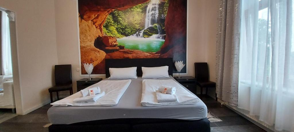 Schlafzimmer mit einem Bett mit Wandgemälde in der Unterkunft Hotel Restaurant Hellas in Gelting