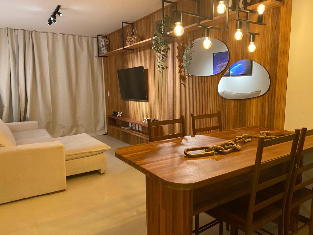 ein Wohnzimmer mit einem Tisch und einem Sofa in der Unterkunft Vilage Villa Andorinha - apt 09 in Mucugê