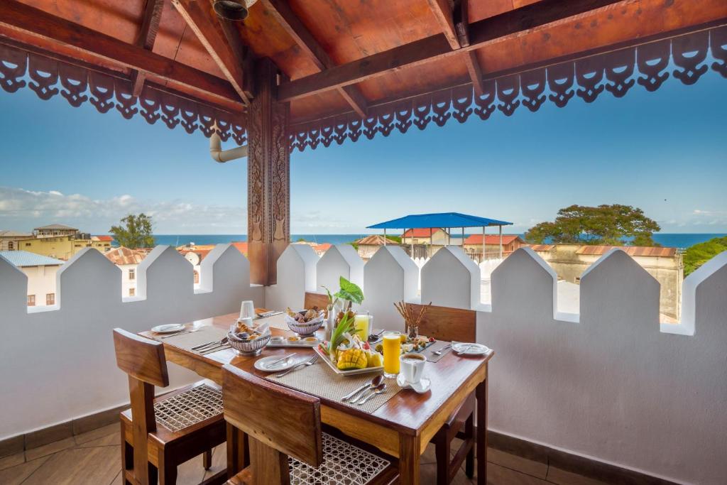 a dining room with a table and a view of the ocean at Spice Tree by Turaco in Zanzibar City