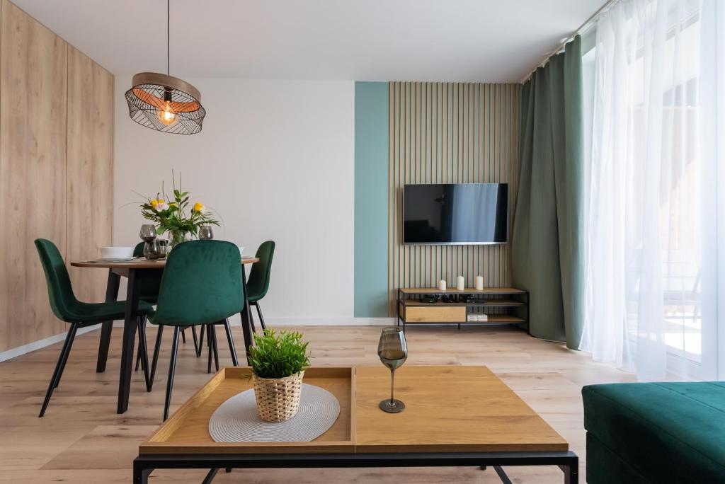 ein Wohnzimmer mit Tisch und Fernseher in der Unterkunft Apartament Mglisty Poranek - Laguna Beskidów - Dream Apart in Zarzecze