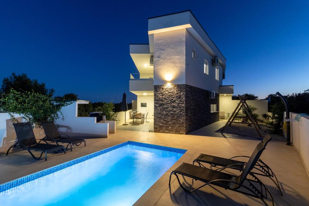 une villa avec une piscine la nuit dans l'établissement Villa White Jasmin, à Medulin