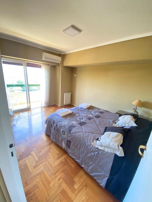 1 dormitorio con 1 cama grande y suelo de madera en Departamento centro Mendoza en Mendoza