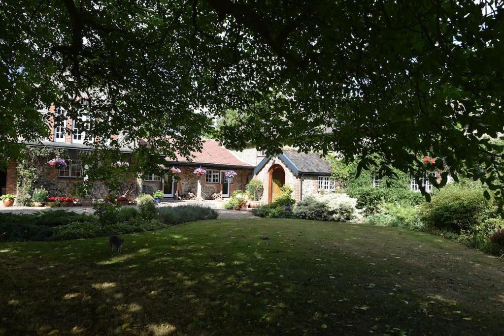 una casa con un gran patio delante de ella en The Mill B&B en Thetford