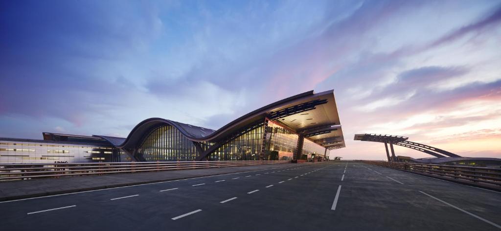 un grand bâtiment avec une route devant lui dans l'établissement Oryx Airport Hotel -Transit Only, à Doha