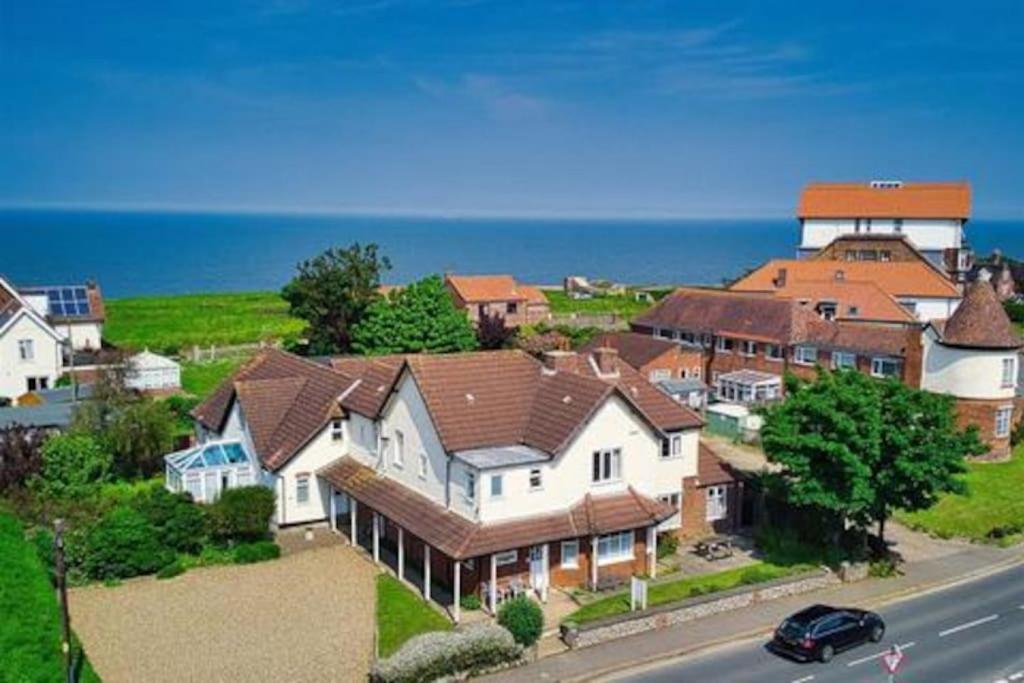 a group of houses on a hill next to the ocean at Overcliff Lodge, Mundesley sea view, sleeps 22 in Mundesley