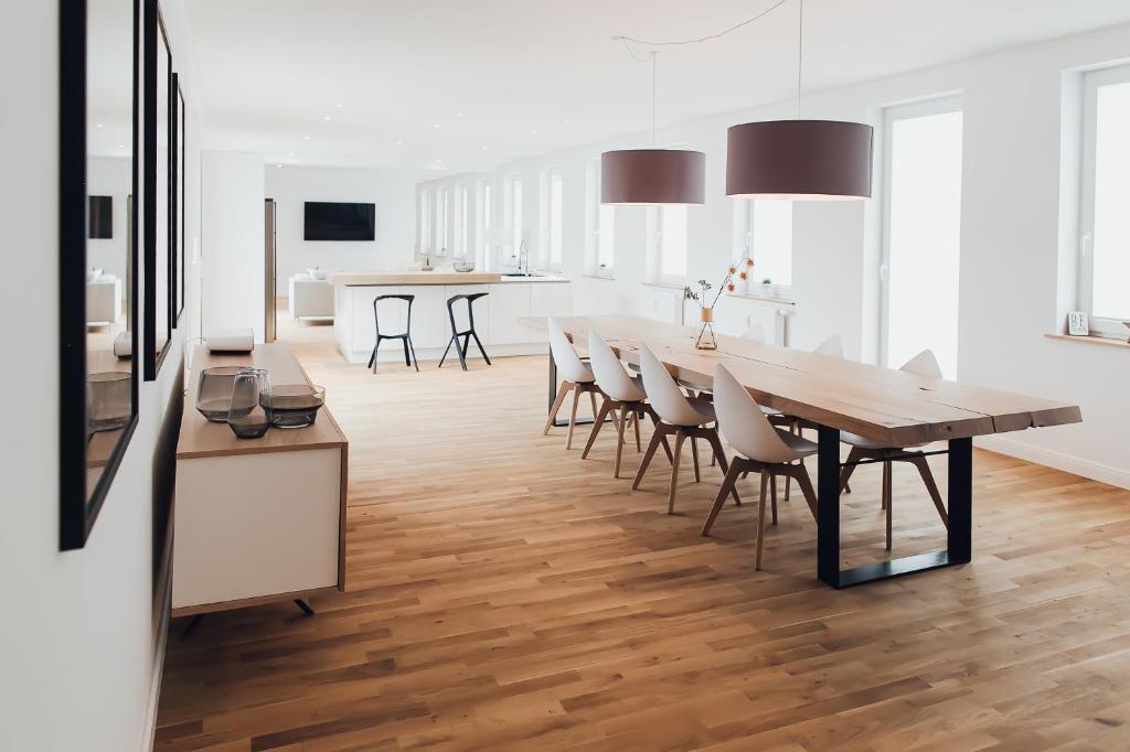 Il comprend une cuisine et une salle à manger avec une table et des chaises en bois. dans l'établissement Louis & Louise Penthouse I Digital Check In, à Brême