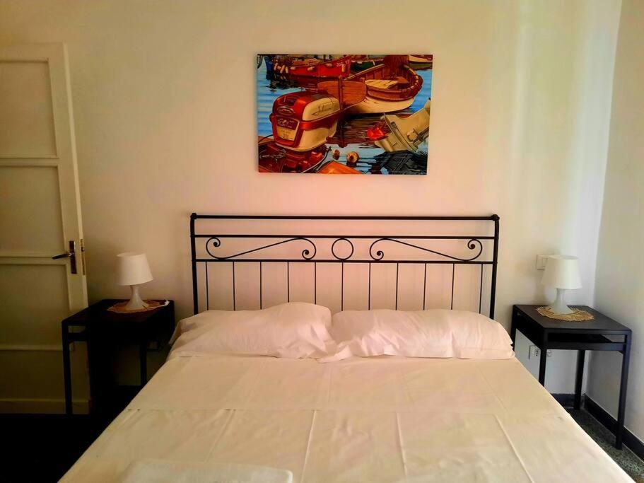 a bed in a bedroom with a painting on the wall at Il limoneto dei Cinque Sensi,apartment with garden in Vernazza