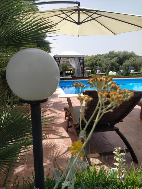 patio con tavolo, sedia e ombrellone di Giardino di Circe a Agrigento