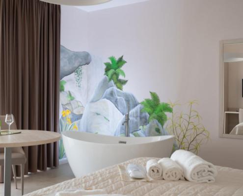 1 dormitorio con bañera y toallas en una cama en Lo Scoiattolo, en Lisciano Niccone