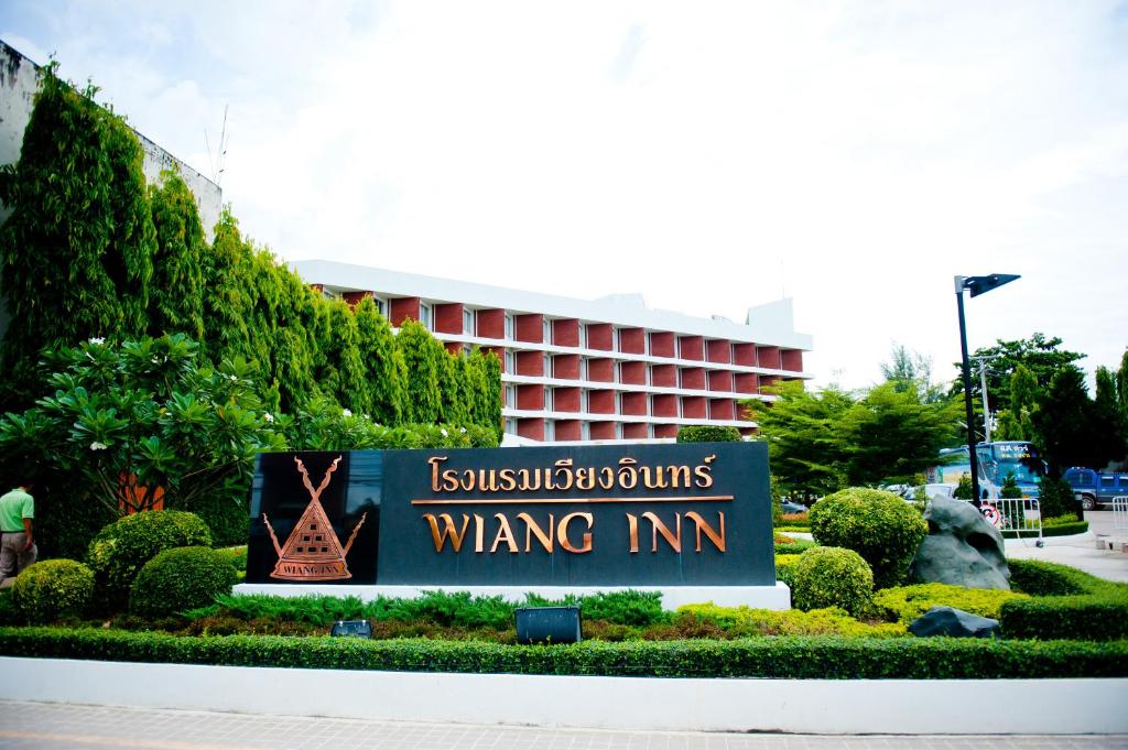 una señal frente a un edificio en Wiang Inn Hotel, en Chiang Rai