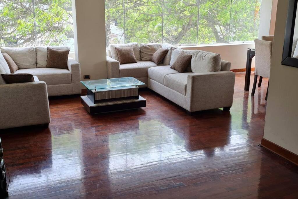 a living room with two couches and a coffee table at Naturaleza y árboles San Isidro in Lima