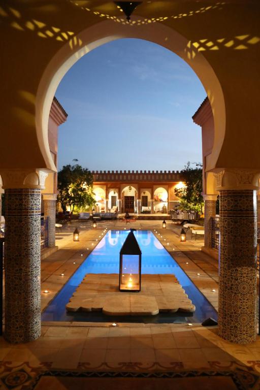 an archway leading to a pool in a building at Riad Ben in Marrakesh