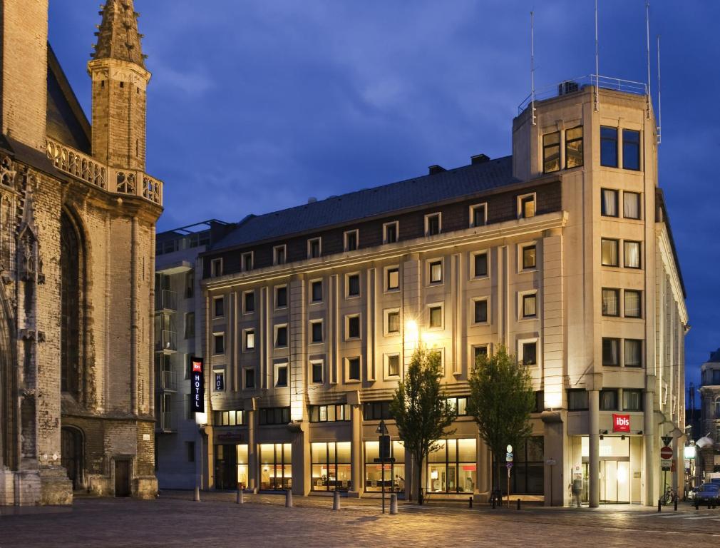 een gebouw met een klokkentoren naast een gebouw bij ibis Gent Centrum St. Baafs Kathedraal in Gent