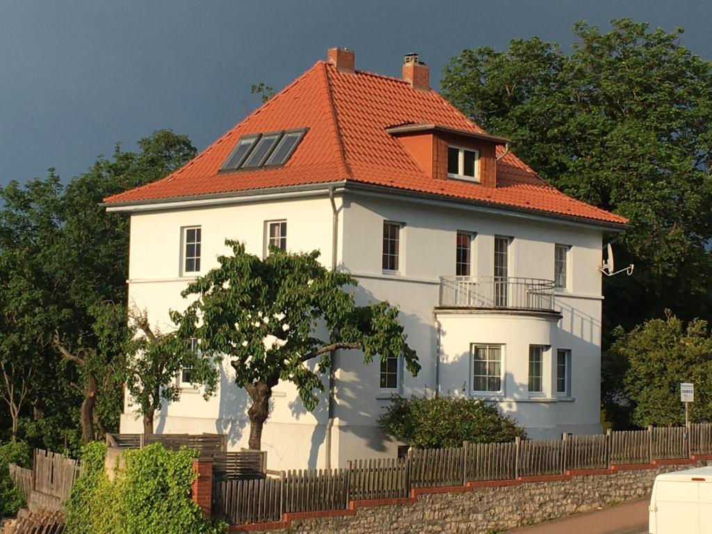 a large white house with an orange roof at Ferienwohnung im Blauen Haus in Bad Suderode