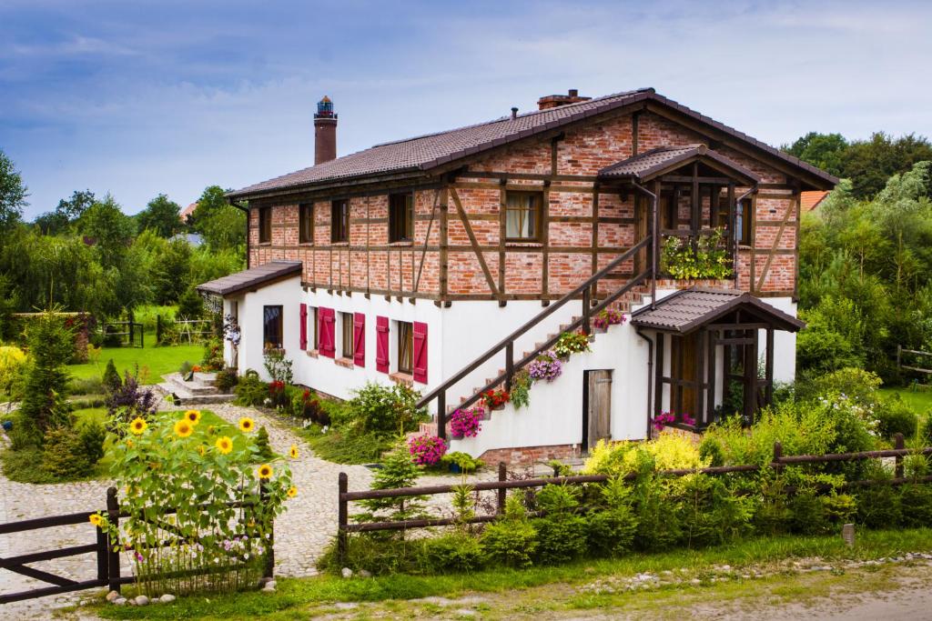 a house with a garden in front of it at SPOKÓJ & DOBRO - slow life apartments in Gąski