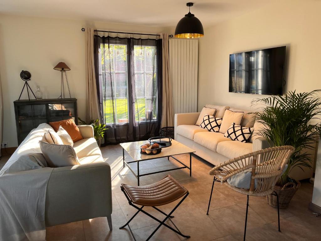 uma sala de estar com um sofá e uma mesa em Honfleur - grande maison familiale avec jardin em Honfleur