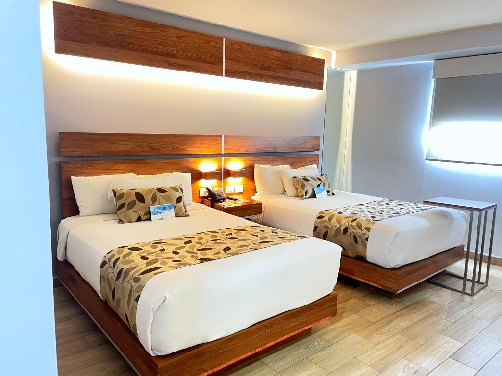 a hotel room with two beds and a window at Sleep Inn Tijuana in Tijuana