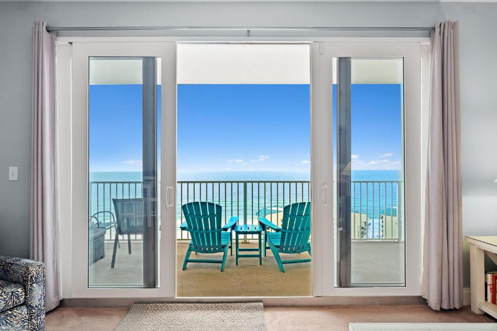 Zimmer mit Glasschiebetüren mit Tisch und Stühlen in der Unterkunft A Shore Thing at Laketown Wharf #1904 by Nautical Properties in Panama City Beach