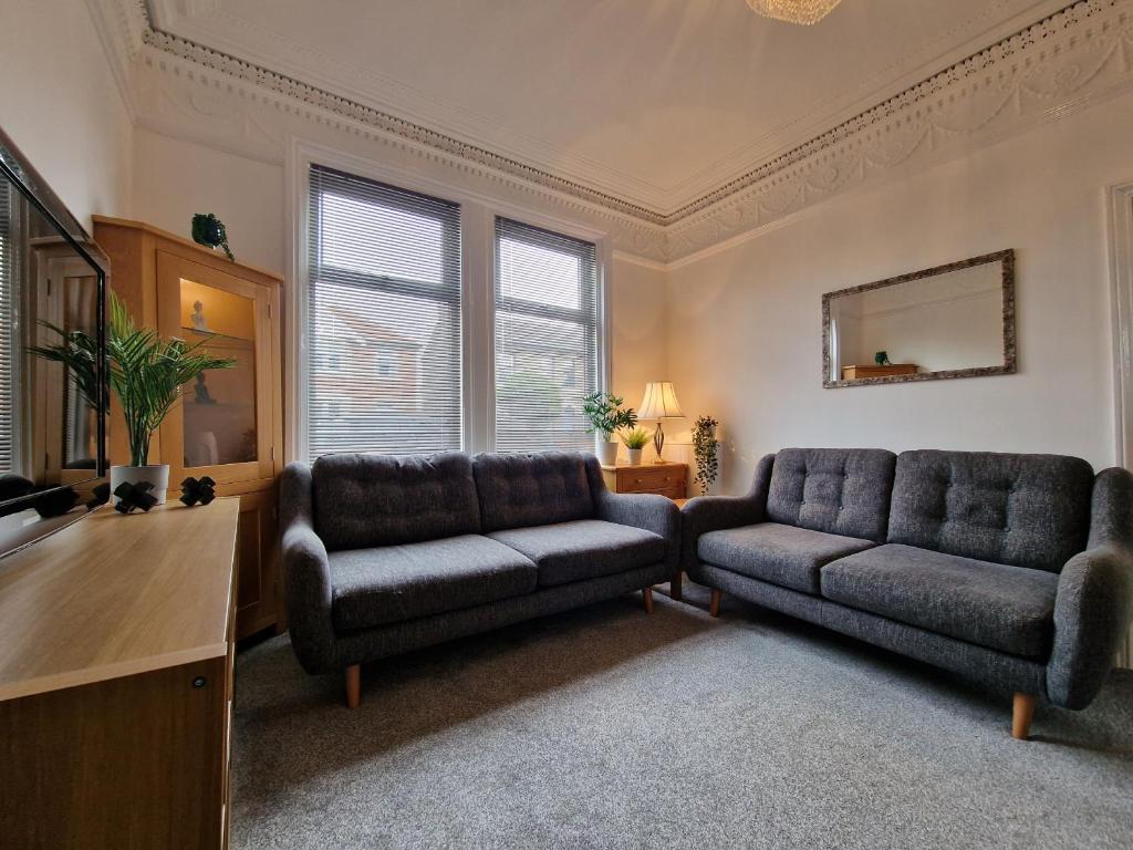 ein Wohnzimmer mit 2 Stühlen und einem Sofa in der Unterkunft DYSA Abbey House in Blackpool