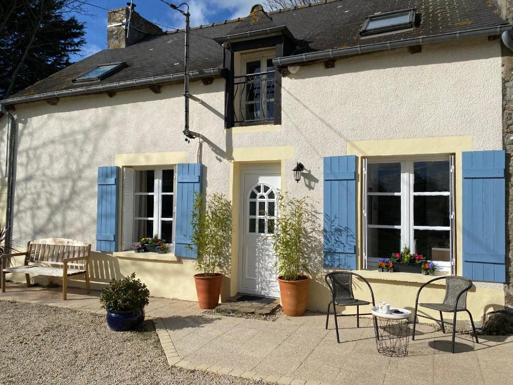een wit huis met blauwe luiken en stoelen bij « La Belle Vie » Brittany, ideal for 2 to 6 people 