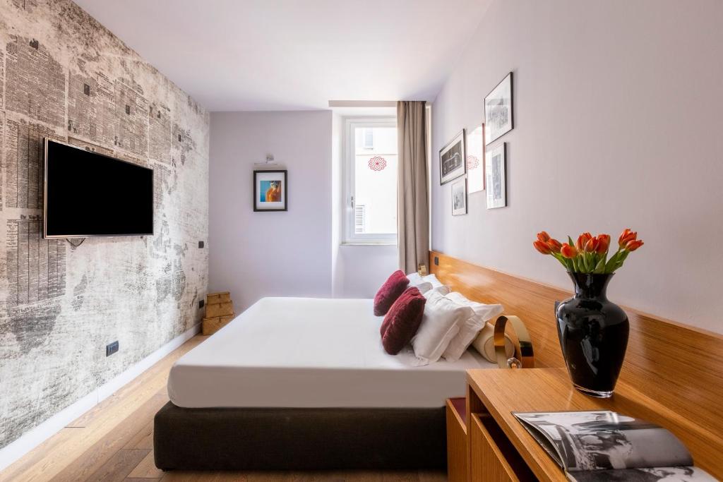 a bedroom with a bed and a tv on a wall at DownTown Boutique House in Rome