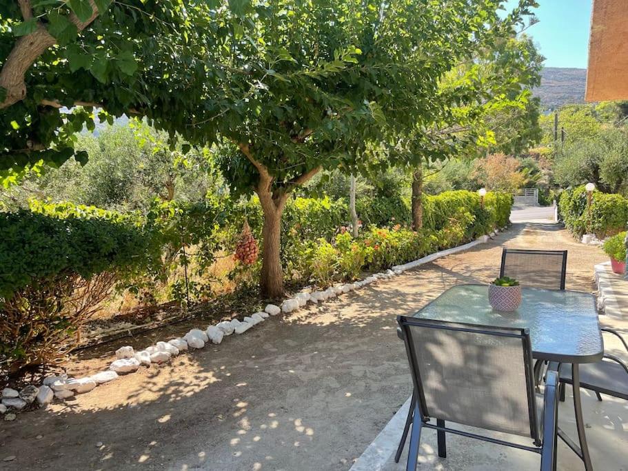 Agrabeli Cottage in Platanos في Plátanos: طاولة وكراسي في حديقة بها شجرة