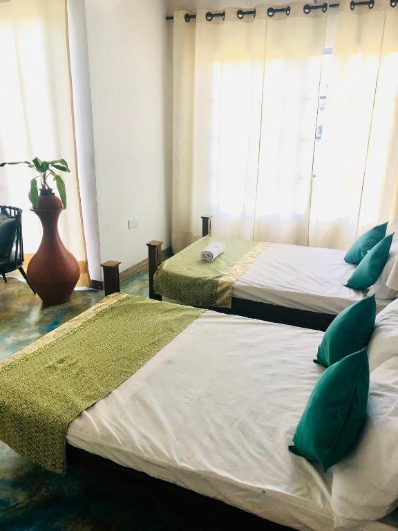Postel nebo postele na pokoji v ubytování Barefoot Inn Kandy