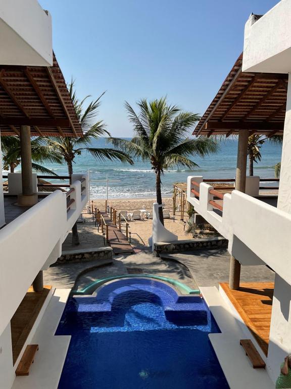 a resort with a swimming pool next to the beach at Casa Faro in Troncones