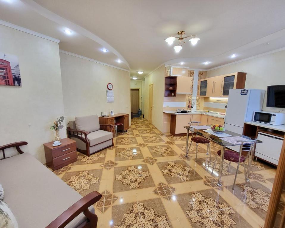 ein Wohnzimmer mit einem Sofa und einer Küche in der Unterkunft Kiev Apartment in Kiew