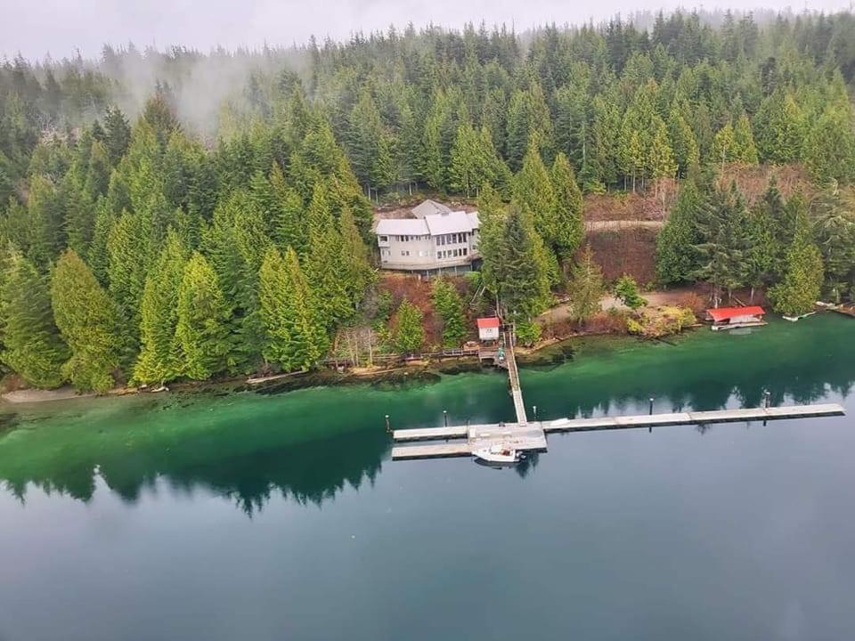 an island in the middle of a lake with a dock at Argo's Landing in Bamfield